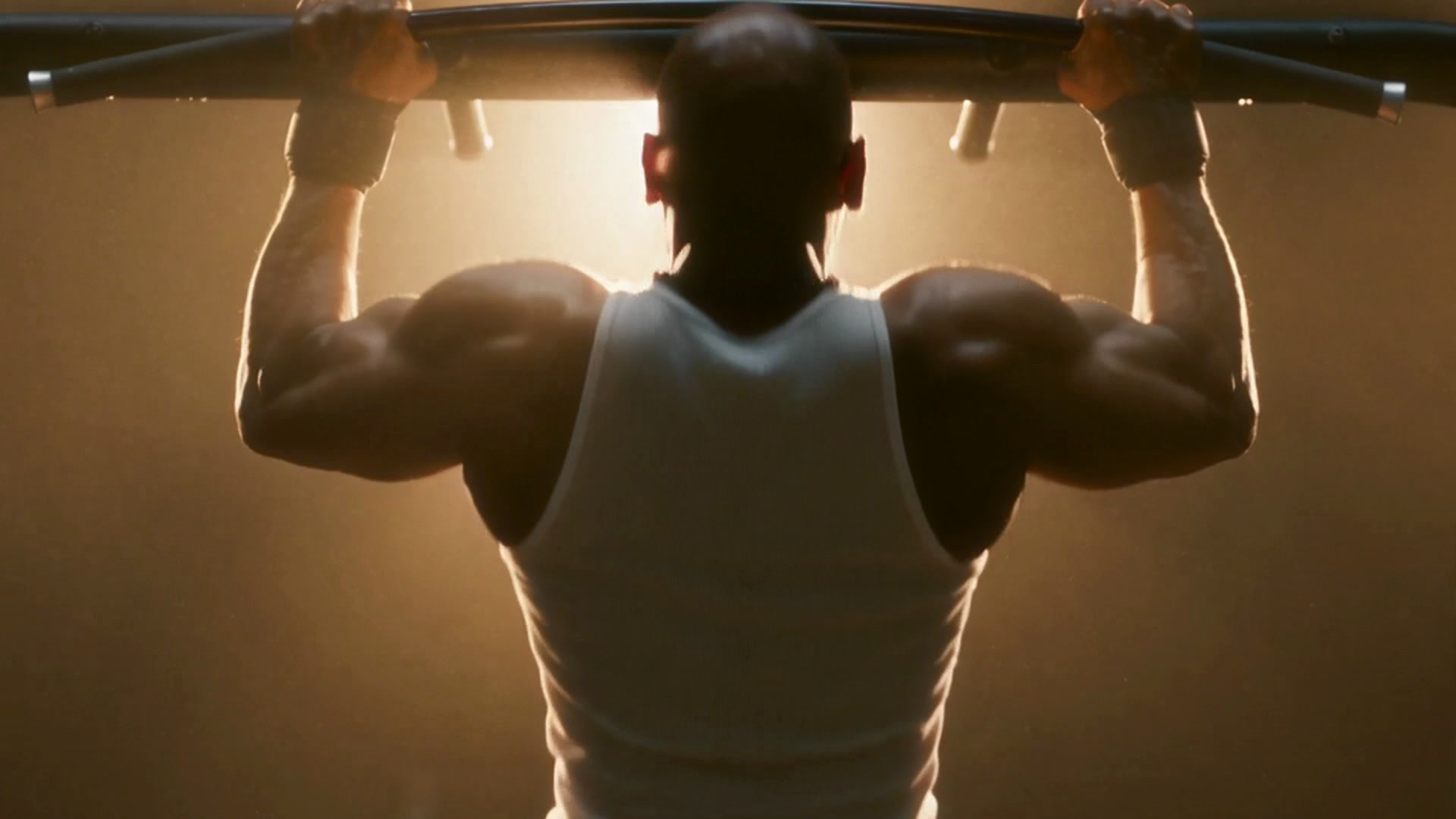 Hanging from a pull-up bar, lit from behind